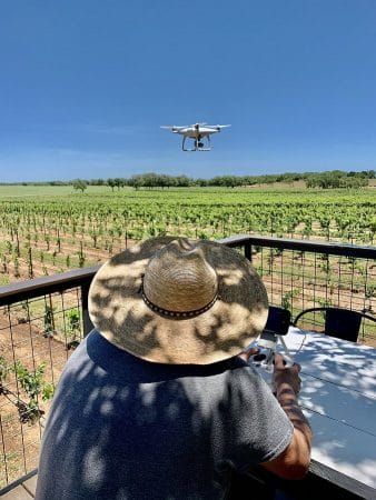 Reagan Sivadon, winemaker and a proprietor of Sandy Road Vineyard using a drone for vineyard photos